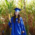 Hallie Sandeen graduation photo standing in corn